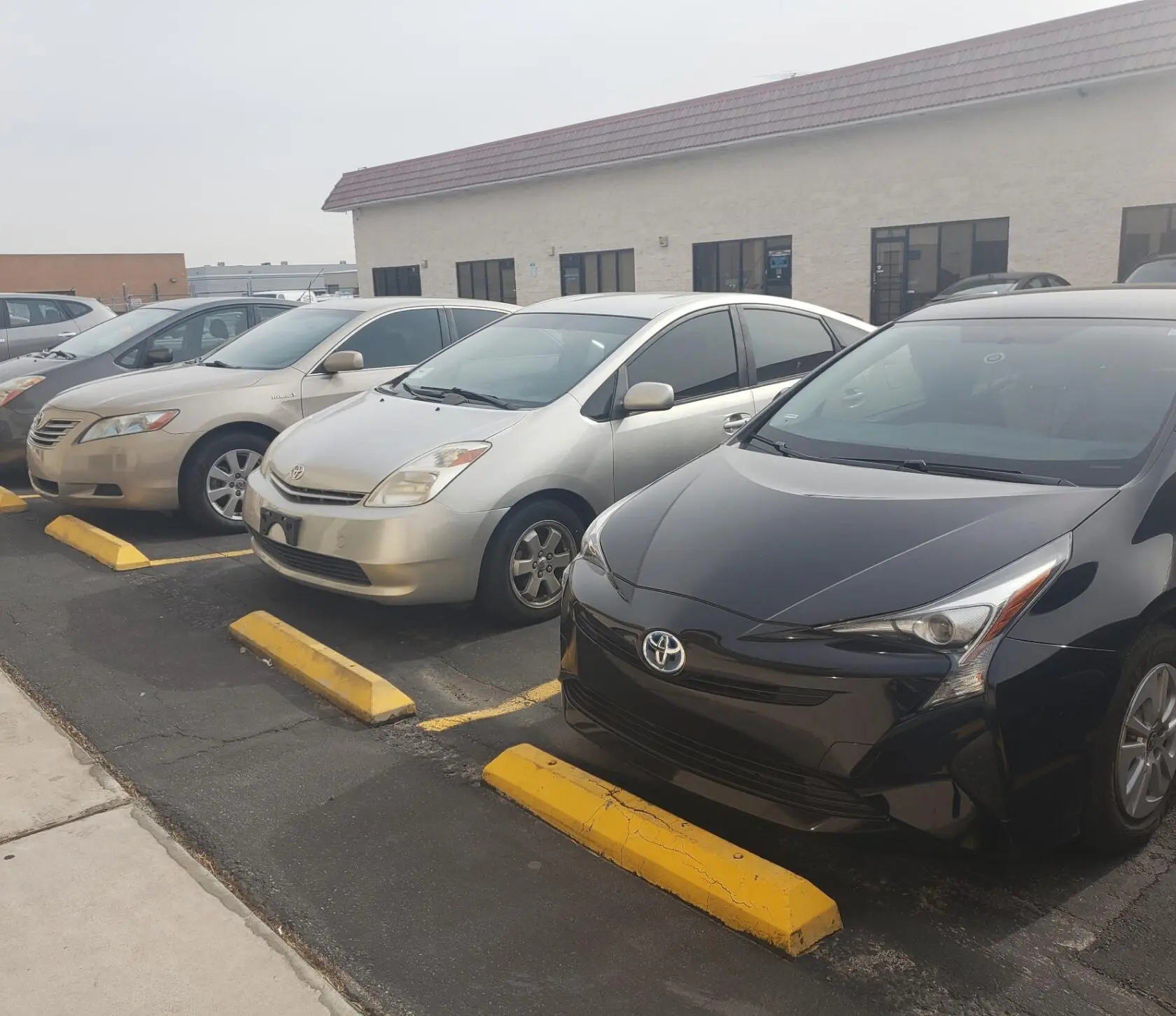 Cars parked in a row outside building.