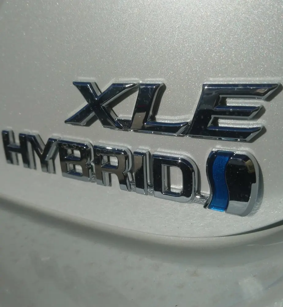 Car badge reading "XLE Hybrid" on vehicle.